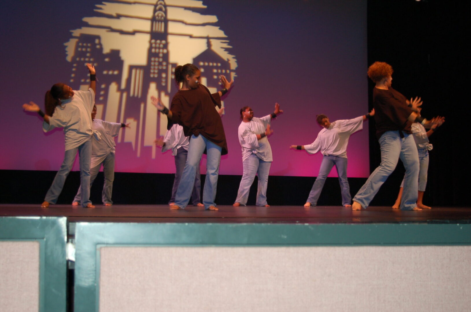 A group of people on stage performing a dance.