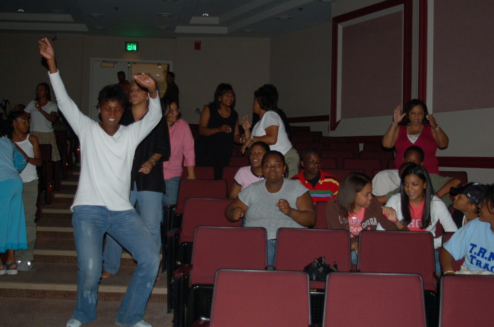 A group of people in the auditorium with one person jumping up and down.