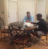 Two men sitting at a table eating food.