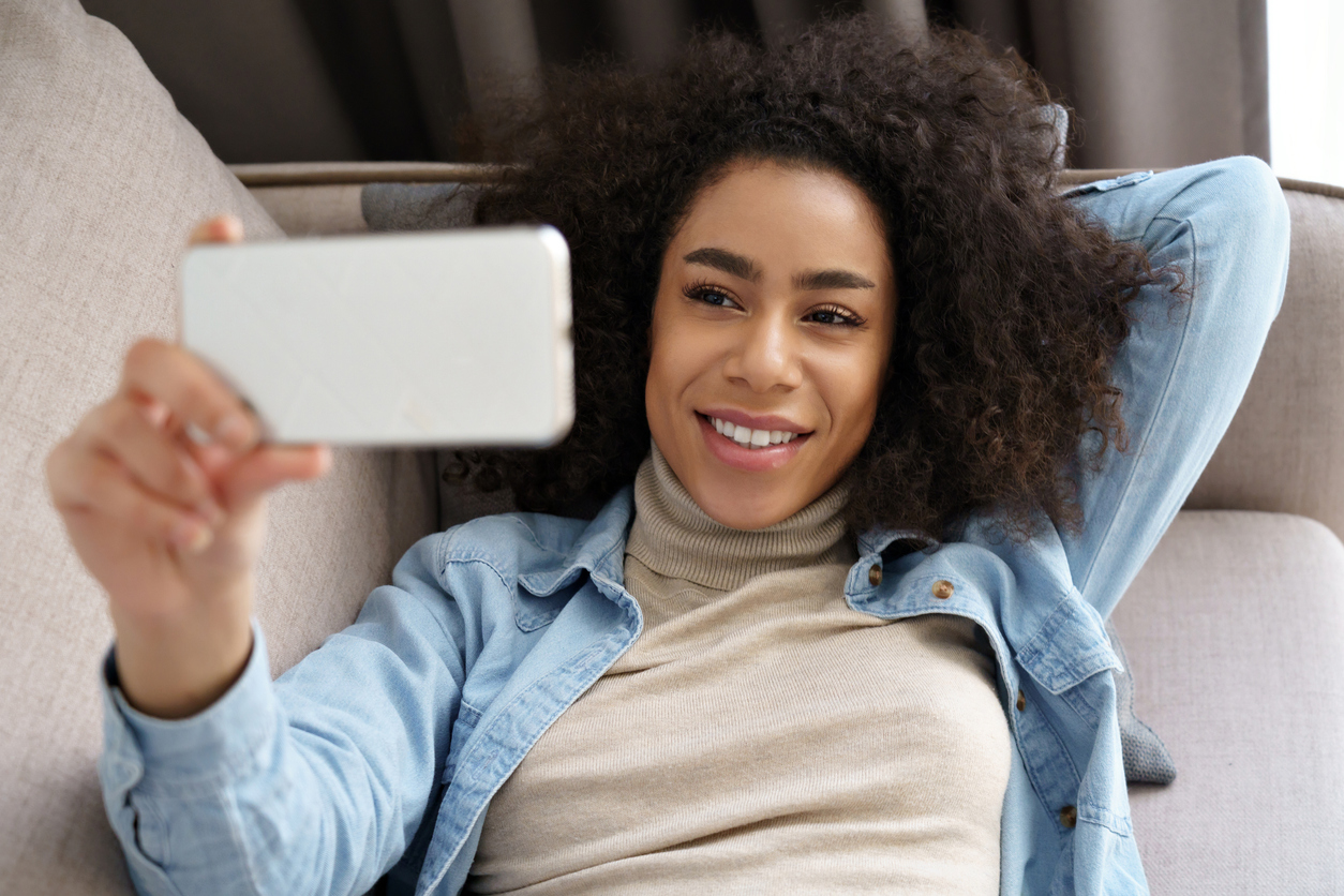 A woman taking a selfie with her phone.
